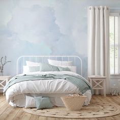 a white bed sitting in a bedroom on top of a hard wood floor next to a window