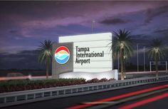 the tampa international airport sign is lit up at night with palm trees in the background