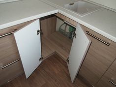 an open cabinet door in the corner of a kitchen