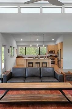 a living room filled with furniture next to a kitchen and dining area in a home