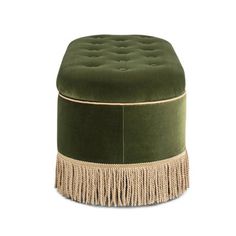 a green ottoman with tassels on the bottom and fringe trimming around it