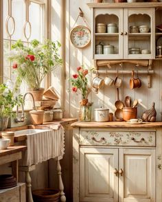 a kitchen filled with lots of pots and pans next to a table covered in flowers