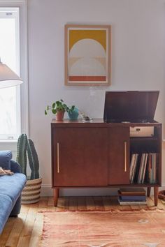 a living room with a blue couch and a wooden cabinet