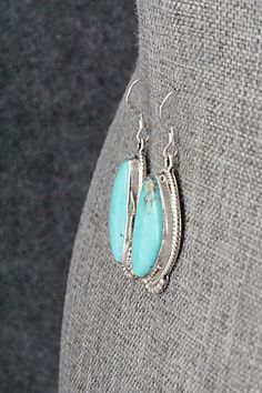 These turquoise and sterling silver earrings were made by Navajo silversmith Verley Betone. The back of the earrings are signed RB and stamped .925.Length: 1 5/8"Width: 5/8"Free shipping on all orders! We ship with USPS and always include tracking. All orders ship within a day of payment.Returns are accepted up to 30 days after you receive your order. Just send us a message. Our shop offers cash back or store credit. The item must be returned in new condition. Southwestern Teardrop Concho Earrings, Southwestern Teardrop Sterling Silver Earrings, Oval Southwestern Sterling Silver Earrings, Nickel-free Turquoise Sterling Silver Earrings, Turquoise Sterling Silver Nickel-free Hoop Earrings, Turquoise Nickel-free Western Earrings, Turquoise Southwestern Nickel-free Hoop Earrings, Bear Carving, White Buffalo