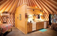 the inside of a yurt with a bed, sink and stove