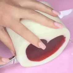 a person cutting something with a pair of scissors on top of a pink countertop