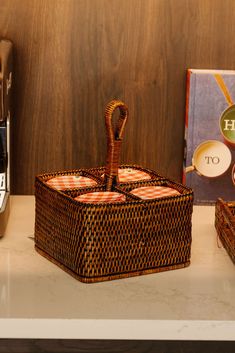 two wicker baskets sitting on top of a counter next to a bottle of wine