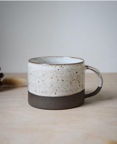 a white and black coffee cup sitting on top of a table