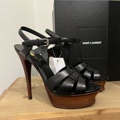 Brand New In Box. No Sign Of Wear. New With Tags. Saint Laurent Interwoven Leather Sandal. T-Bar Front And Oversized Platform Ensure They Exude A 1970s-Meets-Modern-Day Aura, No Matter What You Pair Them With. 4.1" Covered Stiletto Heel; 1.2" Platform; 3.1" Equiv. Tapered Straps Band Open Toe. T-Strap Vamp. Adjustable Ankle Strap. Leather Lining And Sole. High-end Leather Open Toe Heels, High-end Open Toe Leather Heels, Designer Platform Heels With Open Heel, Designer Open Heel Platform Heels, High-end Leather Party Heels, Designer High Heels With Heel Strap, High-end Open Toe Heels With Branded Heel Counter, Black Strappy High Heels, Strappy High Heels Sandals