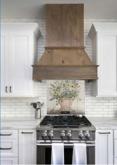 a stove top oven sitting inside of a kitchen next to white cabinets and counter tops