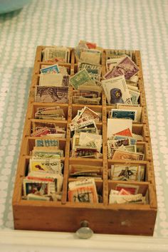 a wooden box filled with lots of different types of stamps on top of a table