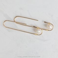 The Zosia earrings are a modern take on the classic pearl earring. Handmade from 18 gauge gold filled wire, these are suitable for sensitive skin and perfect for everyday wear. Understated enough for the office but enough of a statement to show up during those Zoom meetings. • 14k gold filled wire • Freshwater pearls • Measures approx. 2" long Elegant Wire Wrapped Wrap Earrings In Brass, Modern Pearl Earrings With Ear Wire For Everyday, Minimalist Wire Wrapped Pearl Drop Earrings, Elegant Wire Wrapped Earrings For Everyday, Handmade Minimalist Pearl Earrings For Everyday, Minimalist Handmade Pearl Earrings For Everyday, Elegant Everyday Wire Wrapped Earrings, Minimalist Metal Pearl Drop Earrings, Handmade Minimalist Pearl Earrings