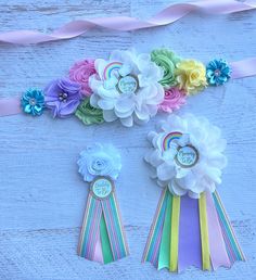 three ribbons with flowers on them sitting next to each other in front of a blue background