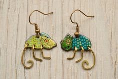 "Chameleon Enamel Earrings, Reptile, Different Pair Earrings, Lizard Earrings, Chameleon Jewelry, Green Enamel Jewelry, Enamel Earrings Width: 2cm / 0.8\" Different pair of chameleon earrings. Enamel earrings, based on copper. Unique piece, with a particular design and graphics. The legs hammered are from brass wires. The graphic was painted with vitreous enamel and used sgraffito technics (scratch work). The graphics was painted with vitreous enamel and used sgraffito technics (scratch work). Both sides of the shape are enameled, the backside is covered with black Shipping Information. In Europe, the delivery time is about 4-5 workdays, to the USA about 12-14 workdays. To worldwide about 12-14 workdays. Shipped in a safe little box package in case of posting. If you have any questions, fe Enameling Jewelry, Vitreous Enamel, Painted Earrings, Funky Earrings, Art Earrings, Enameled Copper, Dope Jewelry, Animal Earrings, Sgraffito