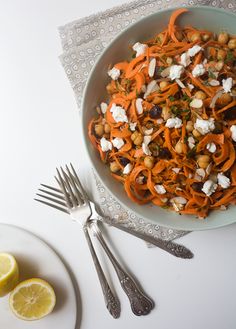 a salad with carrots, chickpeas and feta cheese in a bowl