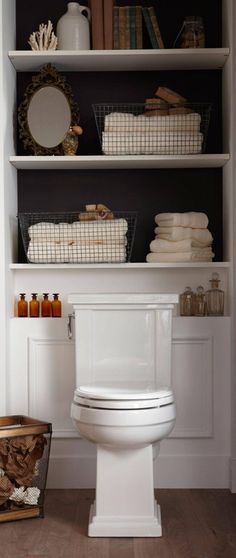 a white toilet sitting in a bathroom next to a shelf filled with books and towels