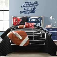 a bedroom with a football themed comforter and pillows