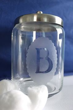 a glass jar filled with cotton balls on top of a white table next to a blue wall