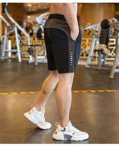 a man standing on top of a gym floor next to a pair of white shoes