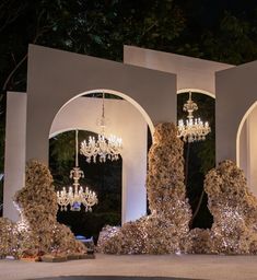 an outdoor area with chandeliers and trees