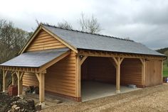 a wooden building with a metal roof and two garages on the side of it