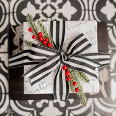 a present wrapped in black and white paper with red berries