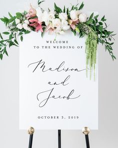 a sign with flowers and greenery on it that says welcome to the wedding of madison and jack