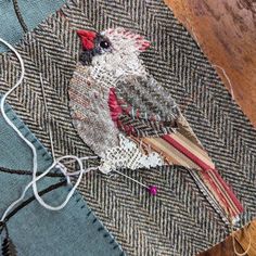 a piece of fabric with a bird on it sitting on top of a wooden table