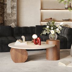 a living room with black couches and white flowers in vases on the coffee table