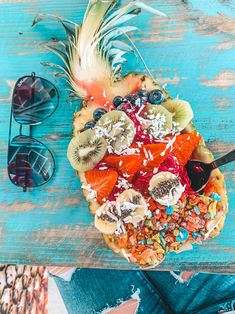 a pineapple, kiwis, blueberries and other fruit on a table