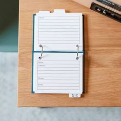 a wooden desk with a notepad and pen on it