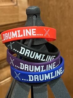 three wristbands with the words drumline and drumming written on them in different colors