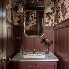 a bathroom with red walls and floral wallpaper