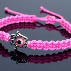 Hand-Made Pink String Hamsa Hand Bracelet With An Evil Eye For Wrist Sizes 6 Inches To 9 Inches, With An Easy To Use Zip Like Function To Fit Your Wrist. Made From High Quality Pink String, It Will Be Sure To Last. The Hamsa Hand Is An Ancient Middle Eastern Amulet Symbolizing The Hand Of God. In All Faiths It Is A Protective Sign. It Brings Its Owner Happiness, Luck, Health, And Good Fortune. Each Bracelet Is Carefully Handcrafted And Give Proper Time To Ensure Quality. Pink Braided Bracelets For Festival, Pink Resizable Braided Bracelet, Hamsa Hand Jewelry, Bracelet Business, Lava Rock Jewelry, Diy Bracelets With String, Fork Bracelet, The Hand Of God, Red Beaded Bracelet