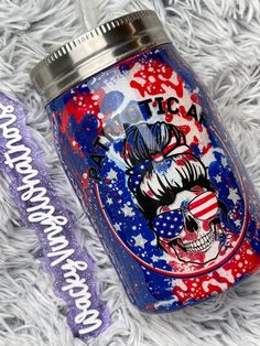 a red, white and blue tumbler with an american flag on it next to a purple straw