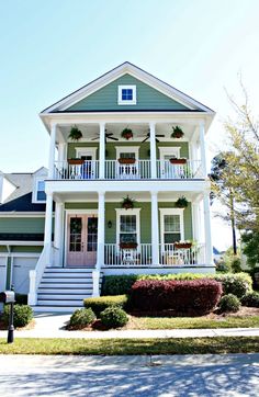 a large white house with porches and balconies on the second story balcony