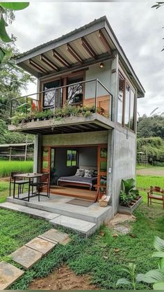 a small house with a balcony on the top floor and an open porch above it