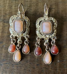 "Pair of vintage Victorian revival Chandelier Earrings pierced wire lever back closure...Features a gold tone curved open cut border with pale gold rhinestone insets accenting a faceted emerald cut opaque Blush colored stone ...Three tear drop dangles with stones in shades of the blush & darker tan...Different lighting and backdrop slightly changes the stone shades to appear more pinkish. Measurements: 2\" long  x  3/4\" wide ... Nice pre used condition with all stones in place My items are most Vintage Revival, Victorian Revival, Colored Stone, Vintage Chandelier, Pale Gold, Gold Rhinestone, Vintage Victorian, Vintage Jewels, Blush Color