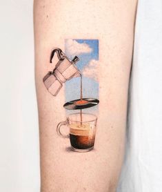 a person with a tattoo on their arm that has coffee being poured into a cup