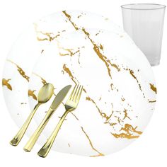 a white plate with gold foiled utensils and a glass on the side