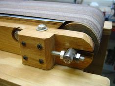 a close up of a wooden bench with two screws