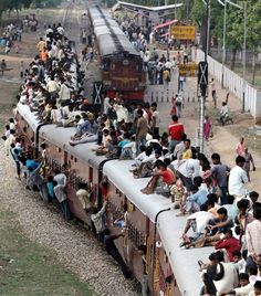 many people are sitting on the side of a train