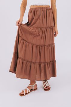 Swish and twirl in our What A Feeling Skirt! This tiered maxi skirt features a playful ruffled hem and comfortable elastic waistband for a versatile and flattering fit. Get ready to turn heads and feel fabulous in this must-have addition to your wardrobe. Details Tiered maxi skirt Ruffled hem Elastic waistband Sizing Approximate measurements: SIZE LENGTH WAIST Small 37" 28" Medium 37" 30" Large 37.5" 32" Fabric has stretch in the waistband Model is 5’8 wearing small Material 100% RayonHand wash Happy Homemaking, Nursing Friendly Dress, Plus Jumpsuit, Ruffle Maxi Skirt, Tiered Maxi Skirt, Exclusive Dress, Basic Dress, Tank Top Long Sleeve, Plus Dresses