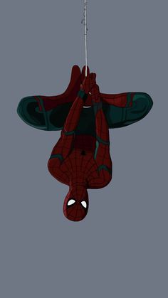 a spider man hanging upside down in the air with his hands up to his face