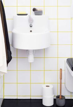 a white sink sitting next to a toilet on top of a tiled floor in a bathroom