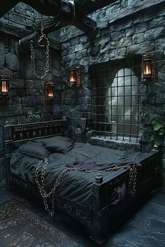 a bed in a stone walled room with chains hanging from the ceiling and windows on either side