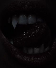 a woman's mouth with dark lipstick and teeth