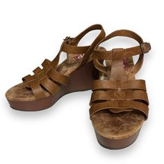 Style Name: Pleasing Color: Cognac Shoe Type: Wedge Platform: Yes Heel Height: 4” Condition: New, Unused Materials: Manmade Closure: Buckle Inner Sole: Memory Foam Made In China Casual Brown Wedge Sandals With Round Toe, Brown Wedge Sandals With Removable Insole, Casual Wedge Sandals With Removable Insole, Casual Wedge Sandals With Cork-bed Midsoles, Casual Wedge Sandals With Heel Loop, Brown Wedge Sandals With Heel Loop For Vacation, Brown Synthetic Platform Wedge Sandals, Brown Platform Wedge Sandals With Round Toe, Brown Platform Wedge Sandals In Synthetic