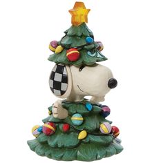 a ceramic christmas tree with a snoopy dog figurine on it's top