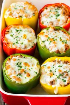 several stuffed peppers in a red casserole dish